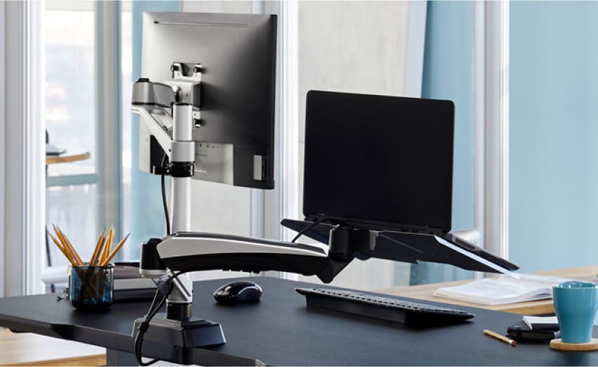 monitor arm and laptop stand installed on desk